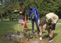 Ben bends to dig hole for flowers